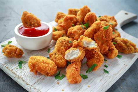 Fried crispy chicken nuggets with ketchup on white board - Tu con i miei occhi