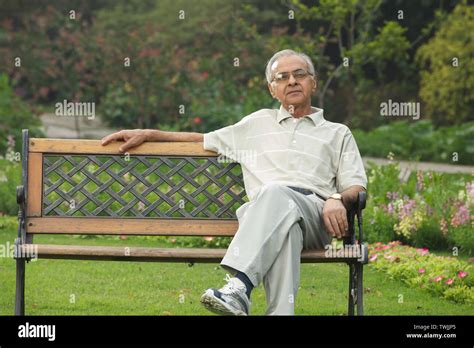 Old man sitting on a park bench Stock Photo - Alamy