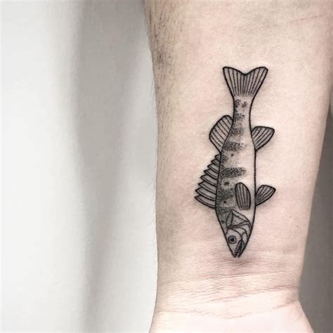 a small fish tattoo on the wrist is shown in black and grey ink, while it appears to be floating