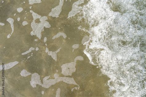 Aerial top view of white waves and water tide coming in at the beach ...