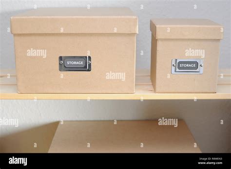 Plain cardboard storage boxes on a shelf Stock Photo - Alamy