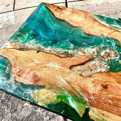 a piece of wood sitting on top of a cement ground covered in green and blue paint