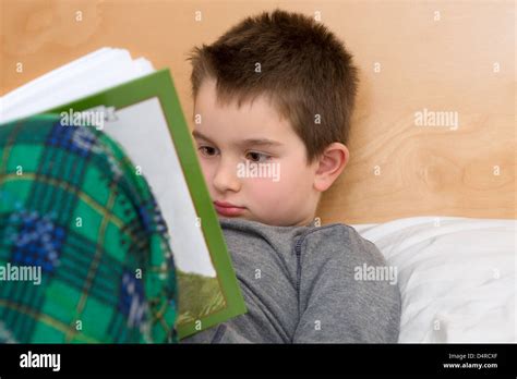 Bed Time Reading in pajamas; eight years old kid reading his book ...