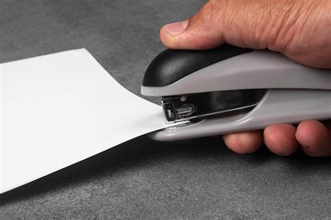 Premium Photo | A man's hand staples documents with a stapler.