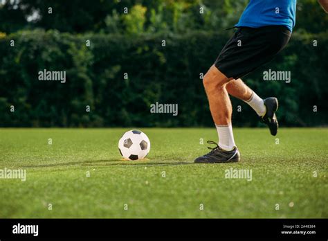 Male soccer player hits the ball on the field Stock Photo - Alamy