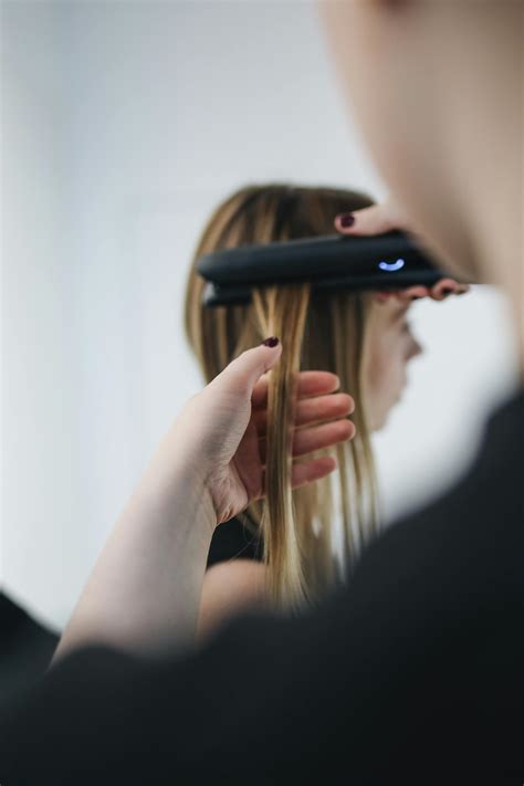Selective Focus Photo of Person Ironing a Woman's Hair · Free Stock Photo