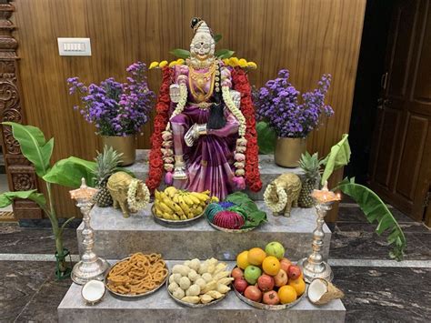 a statue sitting on top of a table filled with fruits and vegtables