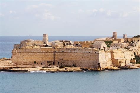 an old castle sitting on top of a rock outcropping in the ocean