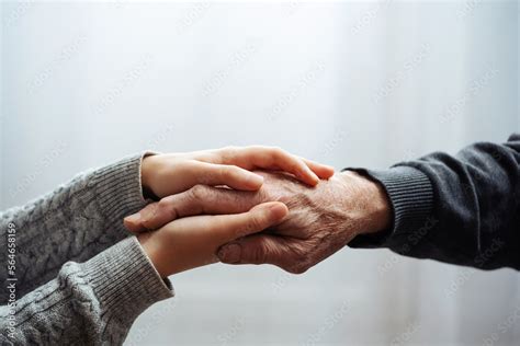 Closeup of hands of old man and a young female hands. Senior man, with caregiver indoors ...