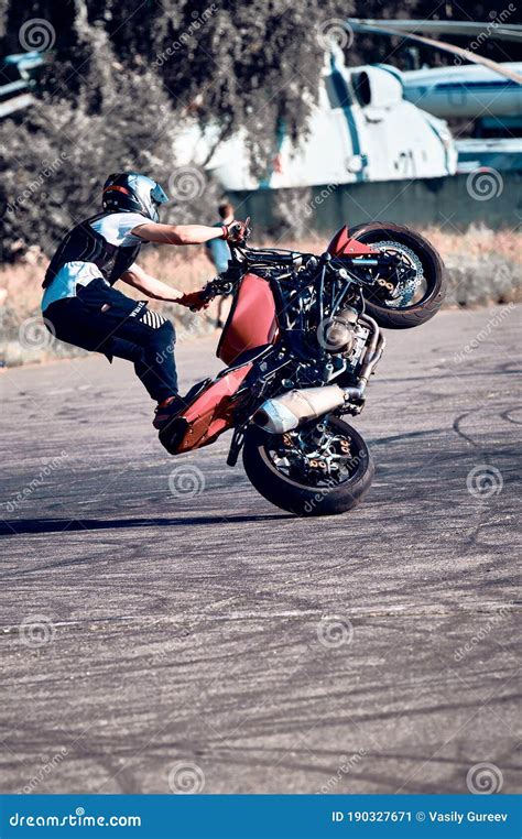 Moto Rider Making a Stunt on His Motorbike. Stunt Motorcycle Rider Performing Motorcycle Show ...