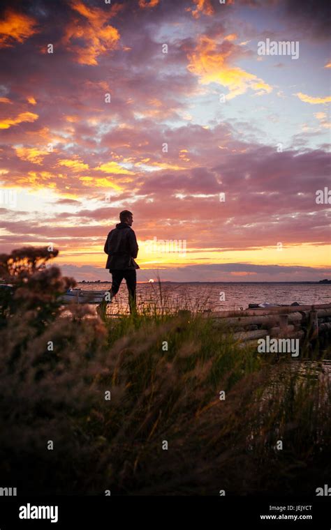 Man walking at sunset Stock Photo - Alamy