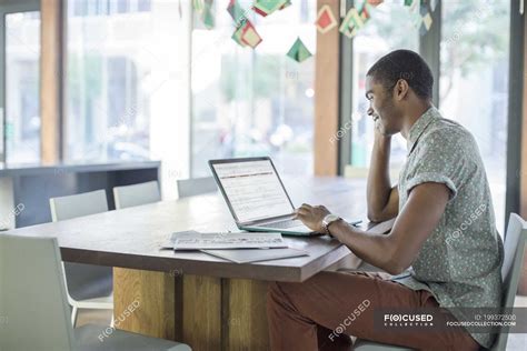 Man working on laptop in office — Mixed Race Person, selective focus - Stock Photo | #199372500