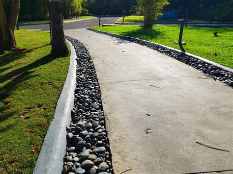 a paved road with rocks and grass on both sides