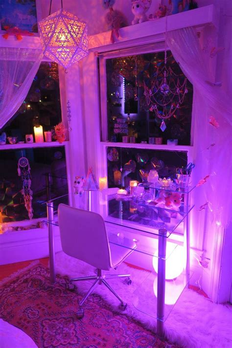 a purple room with a desk, chair and window in the corner is lit up by candles
