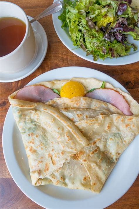 two plates with quesadillas and a cup of tea on a wooden table