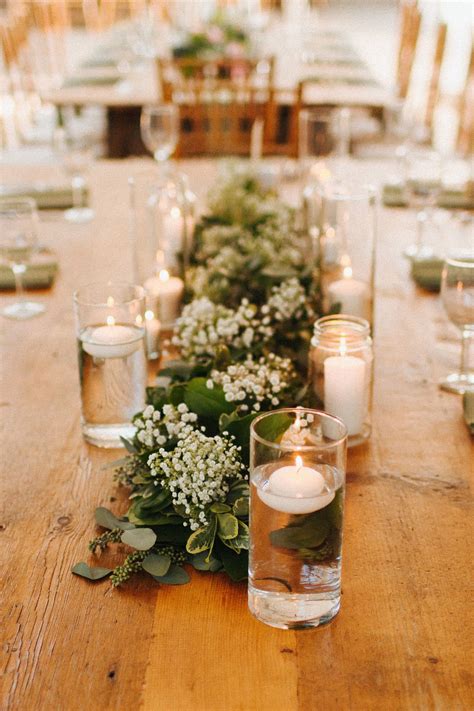 Floating candles and lush greenery runners with babies breath pair ...