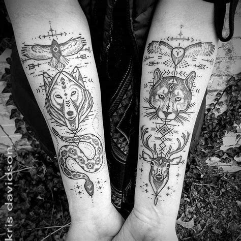 Matching totem tattoos on both inner forearms.