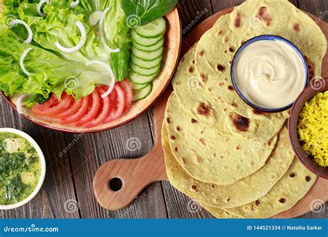 Indian Vegetarian Flat Bread Chapati with Vegetables and Hummus on a Wooden Table Stock Photo ...