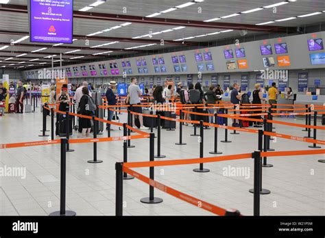 London Luton Airport, UK, check-in hall. Easyjet passengers queue to check in for flights. Luton ...