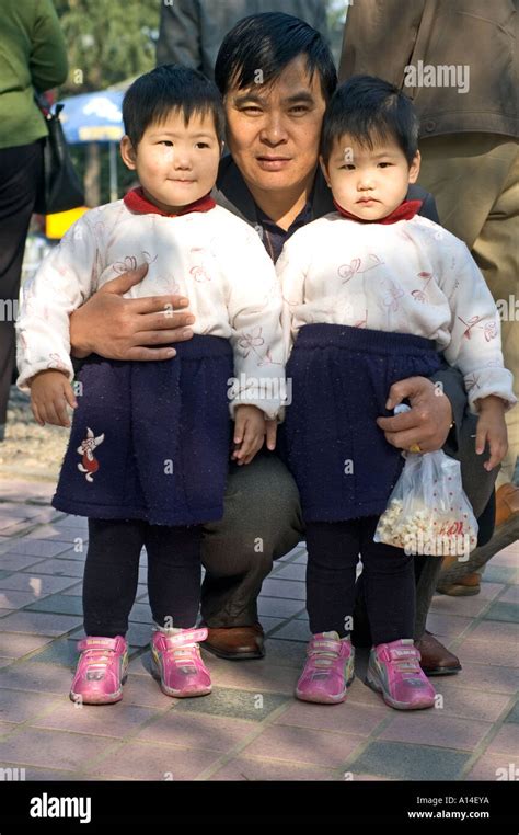 Two Chinese twin child sisters with identical clothes, posing with ...