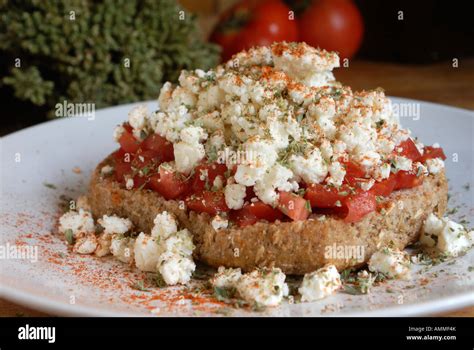 Dakos (Ntakos) traditional Greek starter common in Crete. Dried bread with tomato feta, oregano ...