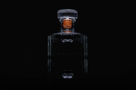 Empty bottle of whiskey on the black background. Photograph by Radomir ...