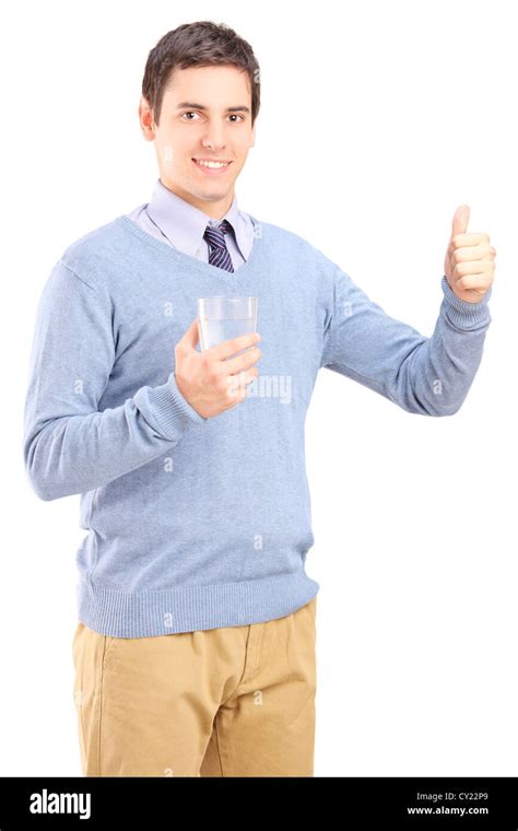 Casual guy holding a glass of water and giving thumb up isolated on ...