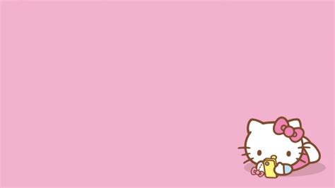 the hello kitty wallpaper is pink and has an image of a cat holding a cup