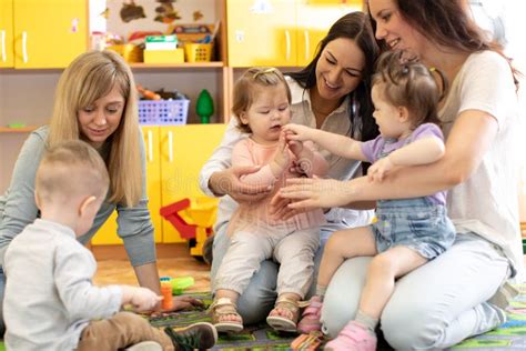 Group of Babies Toddlers Playing with Colorful Educational Toys Together with Mothers in Nursery ...