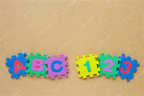 Premium Photo | Alphabet puzzle with number puzzle on wooden.