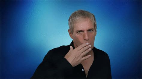 a man with blonde hair is holding something in his mouth