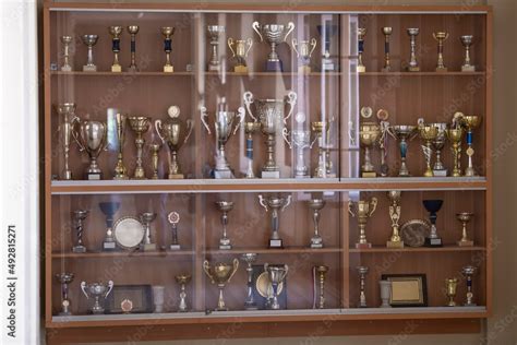 Trophy display case shelf made of glass and wood full of gold and ...