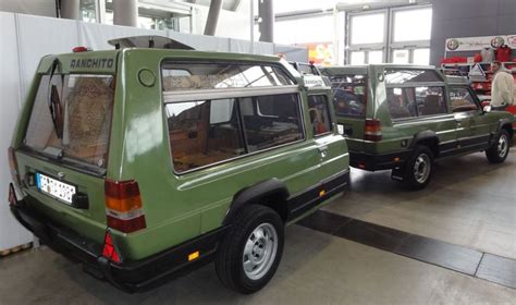 two green cars parked next to each other in a building