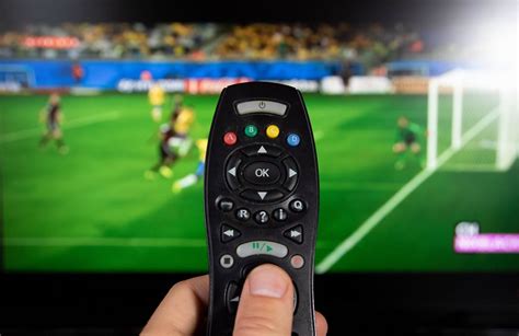Male hand holding TV remote control - Creative Commons Bilder