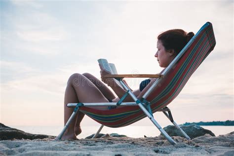 Young Woman Reading a Book on the Beach Stock Photo - Image of sitting, female: 119907312