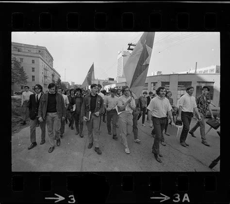 Chanting SDS members, armed with Viet Cong flags, approach main entrance of Massachusetts ...