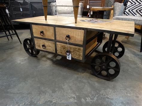 Industrial coffee table features drawers and wheels