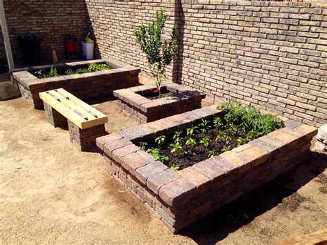 Stone raised garden beds from our house. Vegetables, herbs, and lime tree in the middle ...