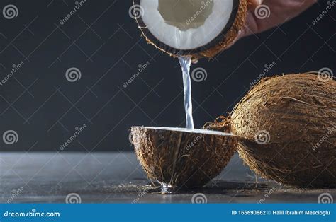 Fresh Cracked Coconut Water or Milk Pouring on Half Coconut Stock Photo - Image of essence ...