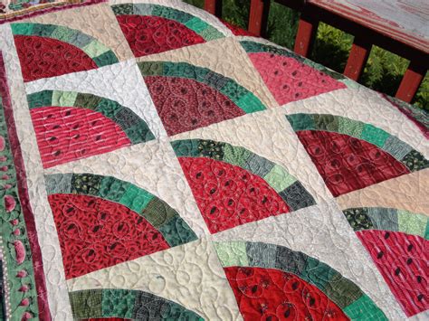 a close up of a quilt on a bench with watermelon slices in the center