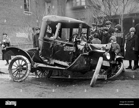 Vintage black and white photograph of an early car crash in Toronto with a small crowd of ...