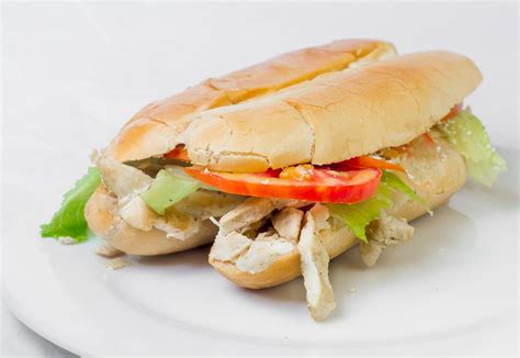 Pan francés relleno de pollo fileteado finamente condimentado, verduras frescas y salsa ...