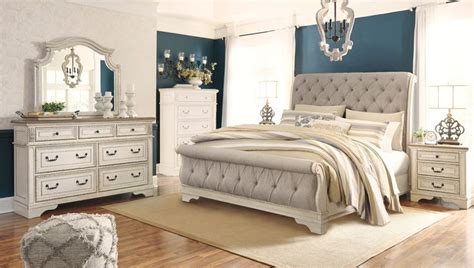 a bedroom scene with focus on the bed, dresser and mirror in the room's center