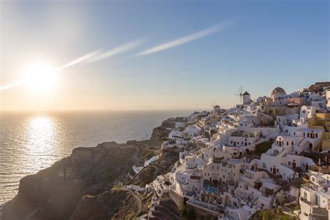 The sunset on the Aegean Sea and the picturesque village of Oia on the Greek island of Santorini ...