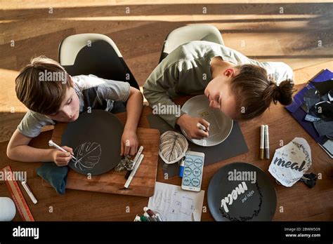 Brother and sister at home painting crockery with porcelain paint Stock ...