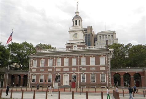 people walking in front of a building with a clock tower