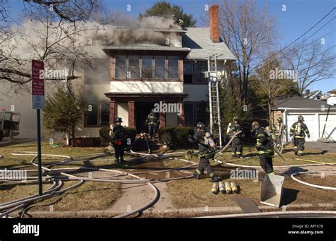 Firefighters fighting a fire House fire Stock Photo - Alamy