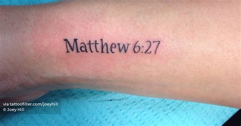 "Matthew 6:27" lettering tattoo located on the wrist.