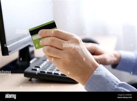 Man holding credit bank card types on PC keyboard. Concept of online shopping and payment ...