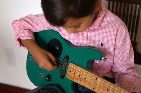 kid-playing-electric-guitar – Children in Homes Music Lessons